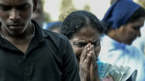 Getty Images Relatives cry at the graveside during the funeral of a victim of the Easter Sunday Bombings at a local cemetery on April 24, 2019 in Colombo,