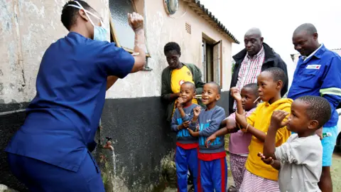 Reuters A health worker teaches children how to wash their hands in Umlazi township, South Africa - Saturday 4 April 2020