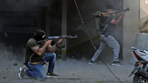 AFP Shia militia fighters fire rifles and rocket-propelled grenades during clashes near the Palace of Justice in Beirut, Lebanon (14 October 2021)