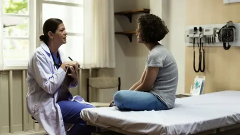 Getty Images A doctor speaks to a patient