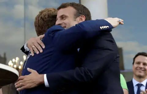 Reuters Macron hugging Elton John