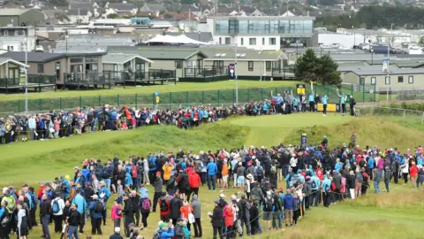 Niall Carson/PA Media Crowds gather as Rory McIlroy tees off during the second day of The Open in 2019
