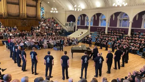 PA Media Peterborough Sings choir performing in Prostate Cancer UK shirts