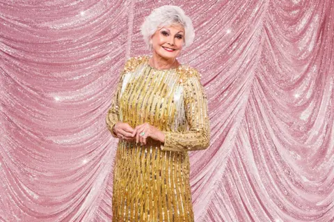 Kieron McCarron/BBC Angela Rippon in a flapper-style gold dress
