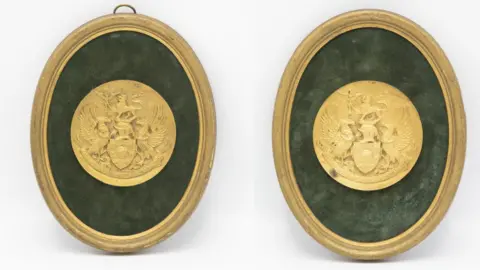 John Rolfe Auctions Two identical round gold medals in gold oval frames.