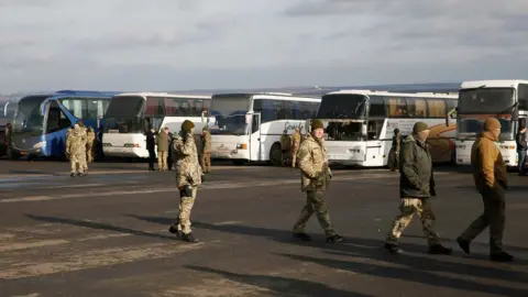 Reuters Servicemen of the Ukrainian armed forces gather near buses transporting prisoners near the city of Bakhmut in Donetsk region