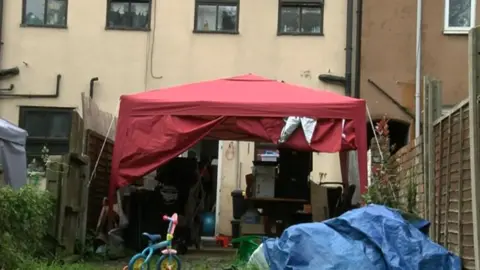 A gazebo outside the couple's home where they store clothes and dry washing