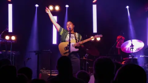 Emmanuel Lwanga Ruti singing at a gig