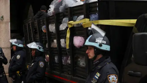 Reuters Police stand guard next to a lorry with confiscated camping equipment