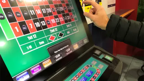 Reuters File image of a man gambling on a fixed-odds betting terminal inside a bookmakers in Manchester, in October 2017