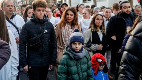 Getty Images Doria Chouviat, Cédric Chouviat's wife, and other relatives leading a march in January