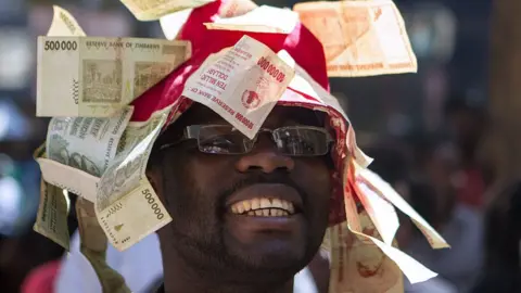 AFP A man wearing a hat decorated with worthless notes, Harare, Zimbabwe - 2016