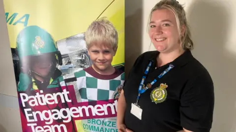 BBC Deanne Hill from South Western Ambulance Service stood next to a patient engagement team banner