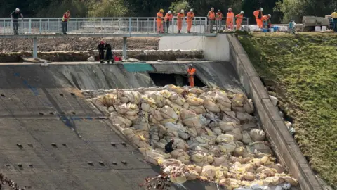 AFP/Getty Images Crews inspect spillway