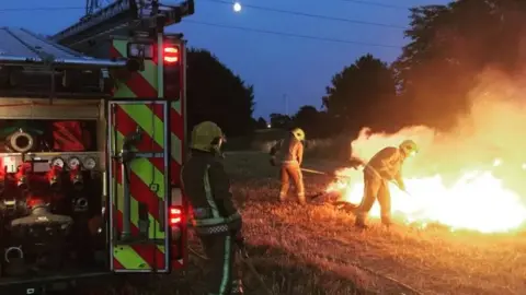 Norfolk Fire and Rescue Service Fire fighters tackle a fire on farmland in Norfolk