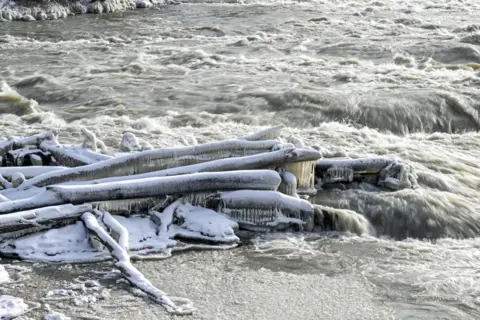 Anadolu Agency Close of wooden logs connected by large icicles