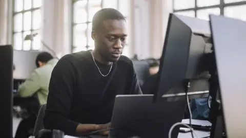 Getty Images Stock image of a programmer working on a computer in an office