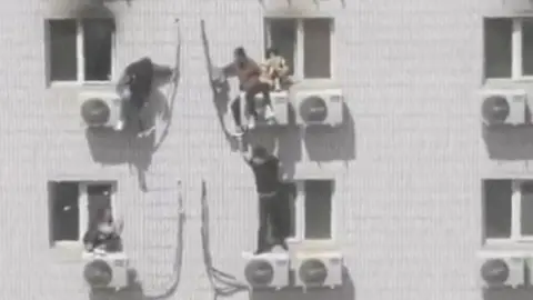 People perched on aircon units