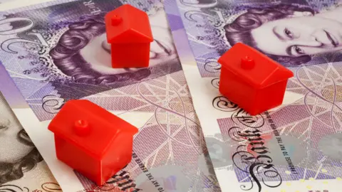 Alamy Red toy houses on paper money