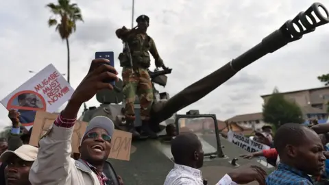 AFP A man takes a selfie of a Zimbabwean Defence Force soldier standing on a tank during a march in the streets of Harare