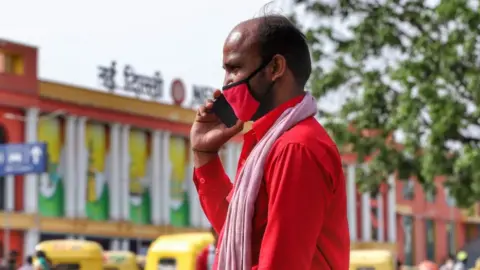 Getty Images Man on Phone outside a Railway Station in New Delhi, India