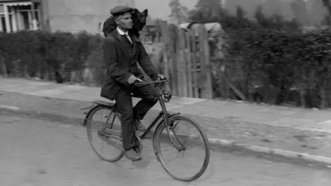 Getty Images Mr Callaway of Morden in London travels to work with his pet dog draped over his shoulder