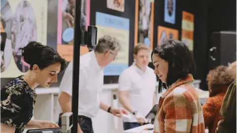 Adegboye Adejumo Woman pays for her goods at the till of Charity Super.Mkt