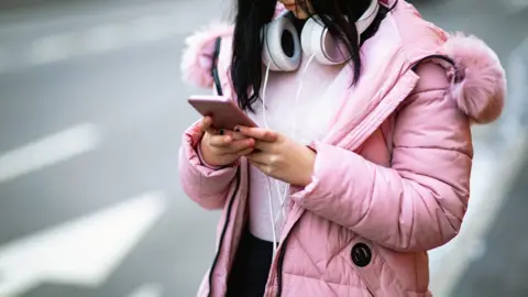 Getty Images Woman on her phone - generic image