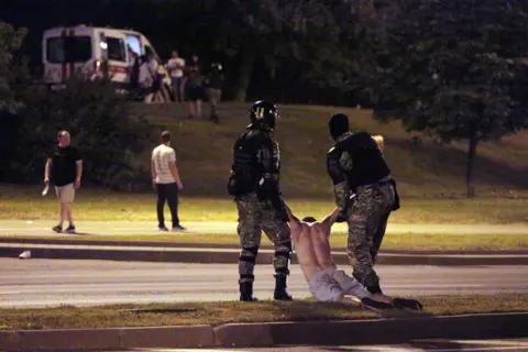 Getty Images Police arrest a demonstrator in Minsk on 9 August