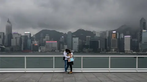 AFP A couple stand on the observation desk at Tsim Sha Tsui in Hong Kong on February 14, 2020