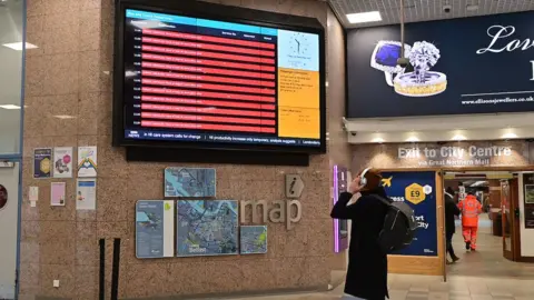 Pacemaker Passenger looking at bus information screen in Europa Bus Centre