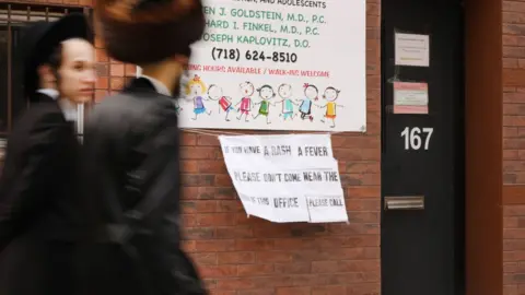 Getty Images A sign posted outside a doctor's office in New York warns measles sufferers to stay away