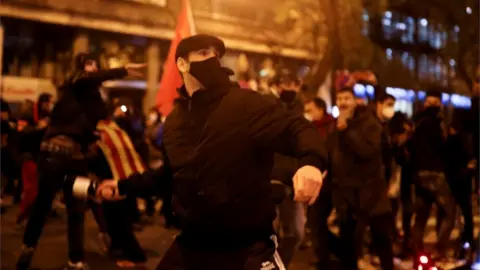 Reuters People throw objects during a protest against rapper Pablo Hasel's arrest