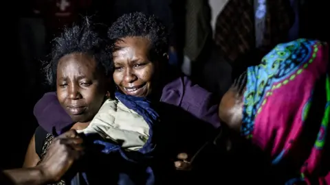AFP Woman is reunited with her family during night-time operations at the hotel