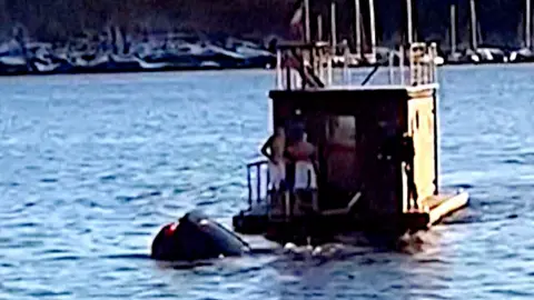Tesla sinks into water next to floating sauna