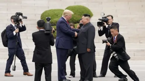 Reuters Donald Trump and Kim Jong-un shake hands at the DMZ (June 2019)