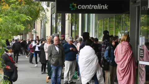 Getty Images People line up for unemployment payments at a welfare office in Sydney