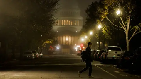 Getty Images A man walking past Congress in the fog