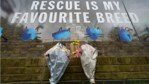 Kirsty O'Connor/PA Flowers are left at Battersea Cats & Dogs Home in south London, where TV presenter and comedian Paul O'Grady worked as the charity's Ambassador.