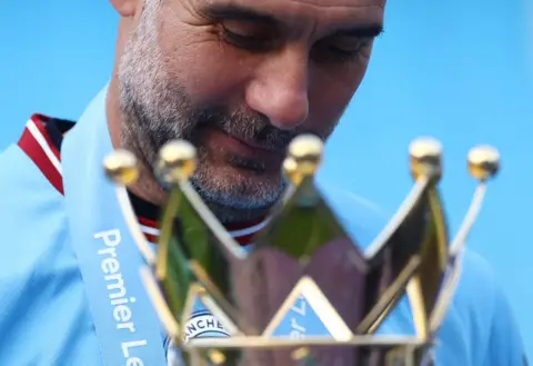 CARL RECINE/Reuters Manchester City manager Pep Guardiola celebrates with the trophy after winning the Premier League