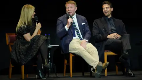 Yui Mok Guy Ritchie and Theo James on stage during a Q&A session after the screening for the premiere of the Netflix series The Gentlemen at the Theatre Royal Drury Lane, London