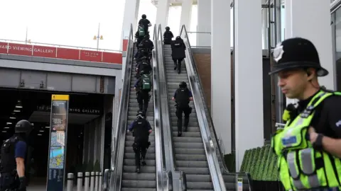 Getty Images Armed police climb escalator in The Shard