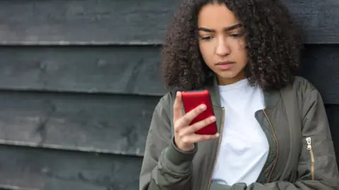 Getty Images Girl using her mobile phone