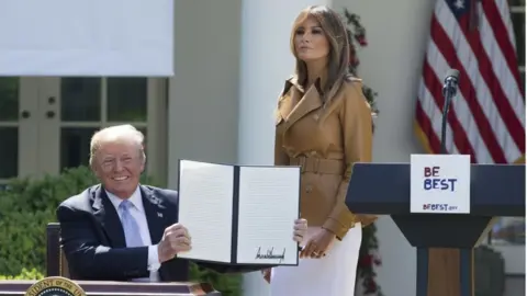 EPA US President Donald Trump holds the proclamation, Melania Trump stands next to him