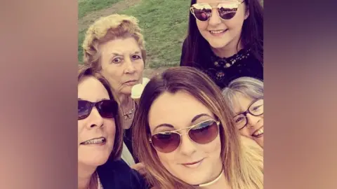 Beryl holding an ice cream with her family