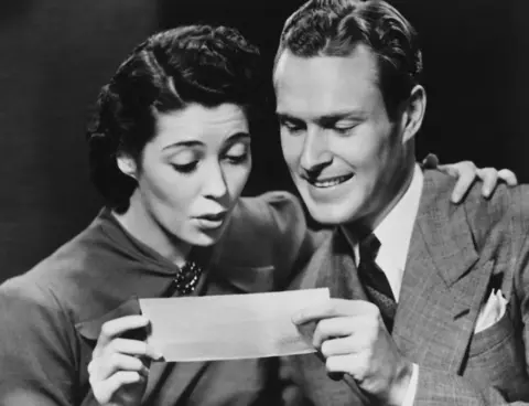 Getty Images Young couple reading telegram in studio. File photo