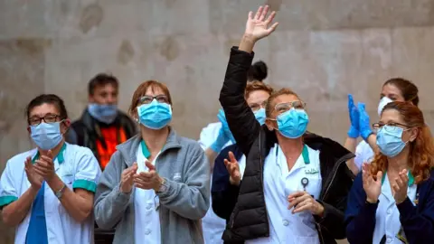 EPA Medical workers react as they take part in the nationwide daily gratitude applause