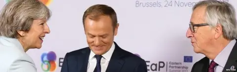 Reuters Theresa May shaking hands with Jean-Claude Juncker, as Donald Tusk looks on