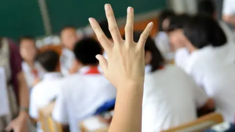 Getty Images Pupil with hand up