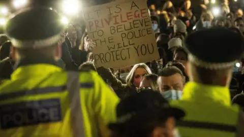 PA Media Woman holds up placard at vigil to Sarah Everard at Clapham Common